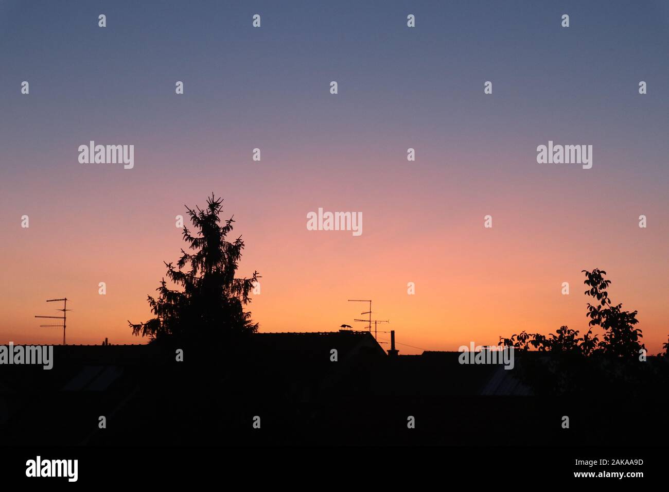 cielo arancione e viola splendidamente colorato sopra il villaggio Foto Stock