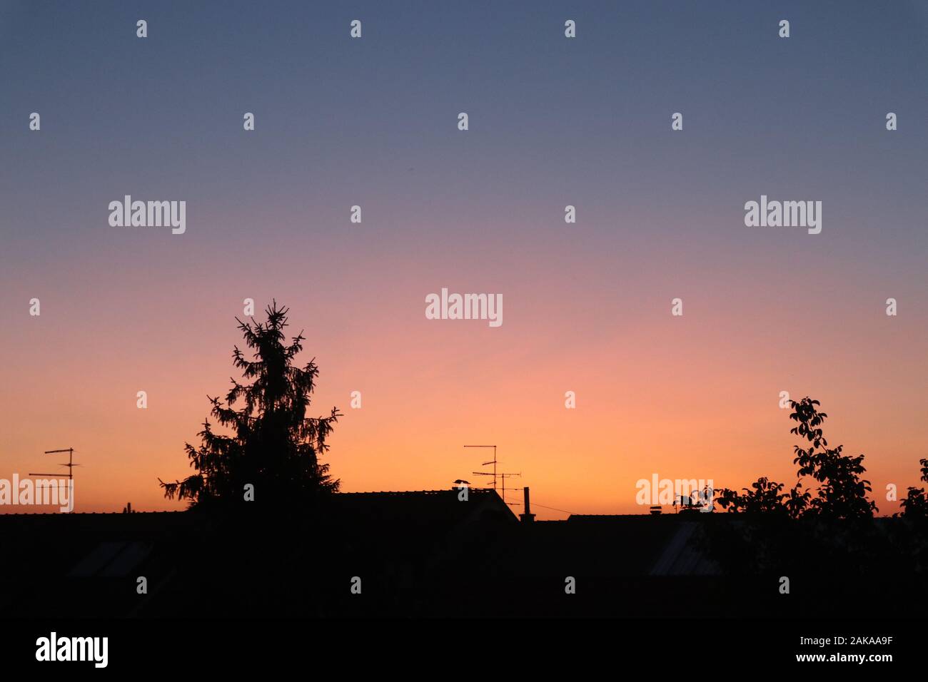 cielo arancione e viola splendidamente colorato sopra il villaggio Foto Stock