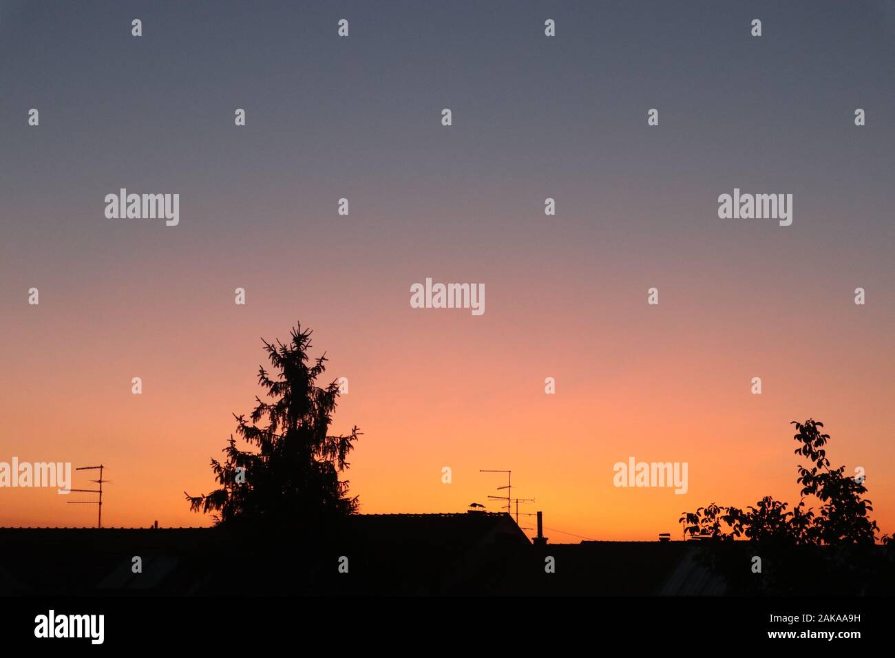 cielo arancione e viola splendidamente colorato sopra il villaggio Foto Stock