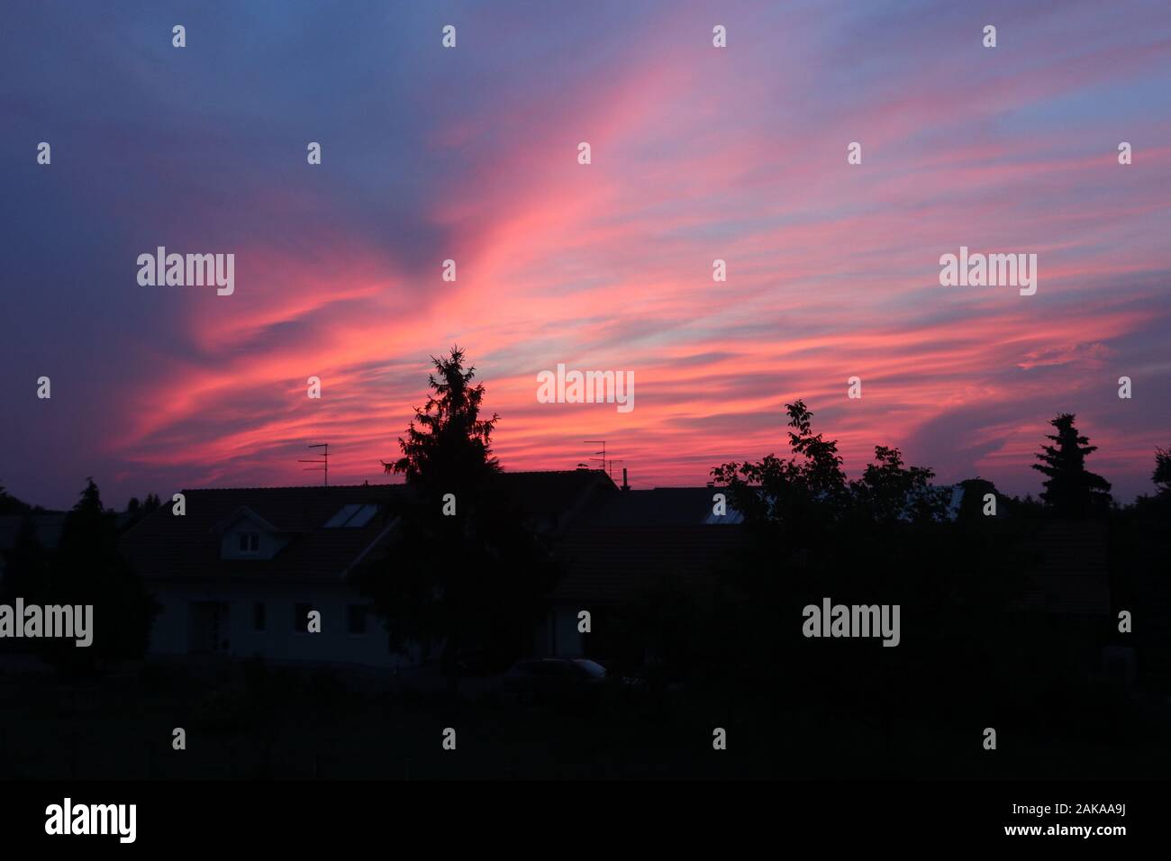 bellissimo cielo rosa fuoco sopra il villaggio Foto Stock