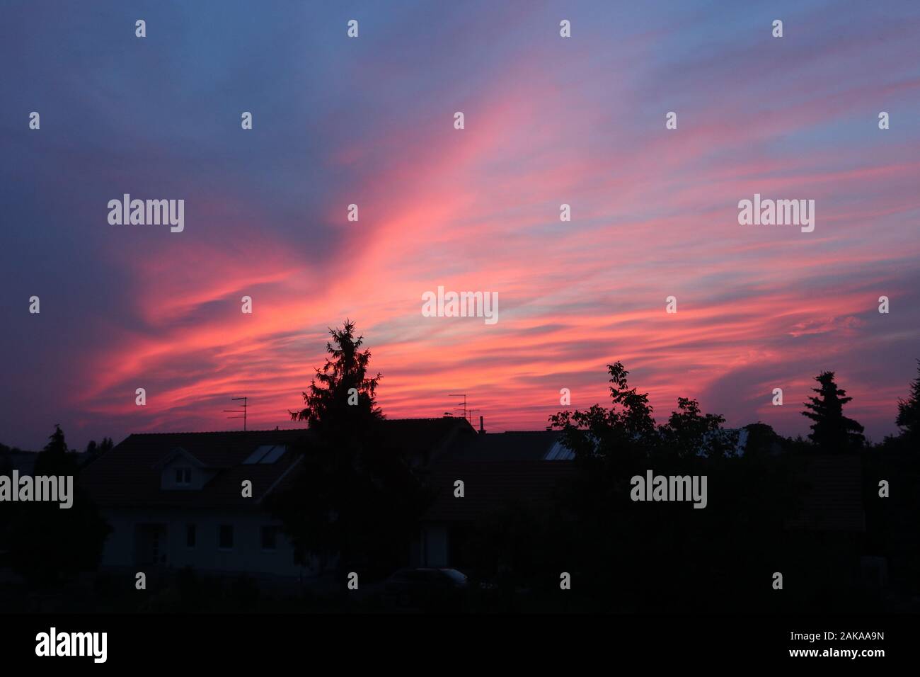 bellissimo cielo rosa fuoco sopra il villaggio Foto Stock