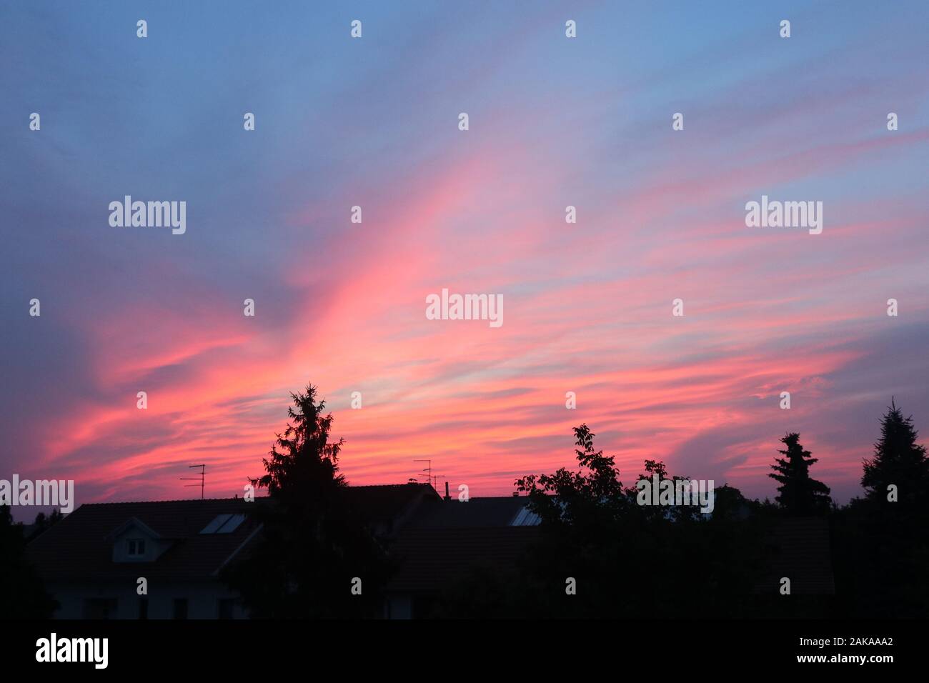bellissimo cielo rosa fuoco sopra il villaggio Foto Stock