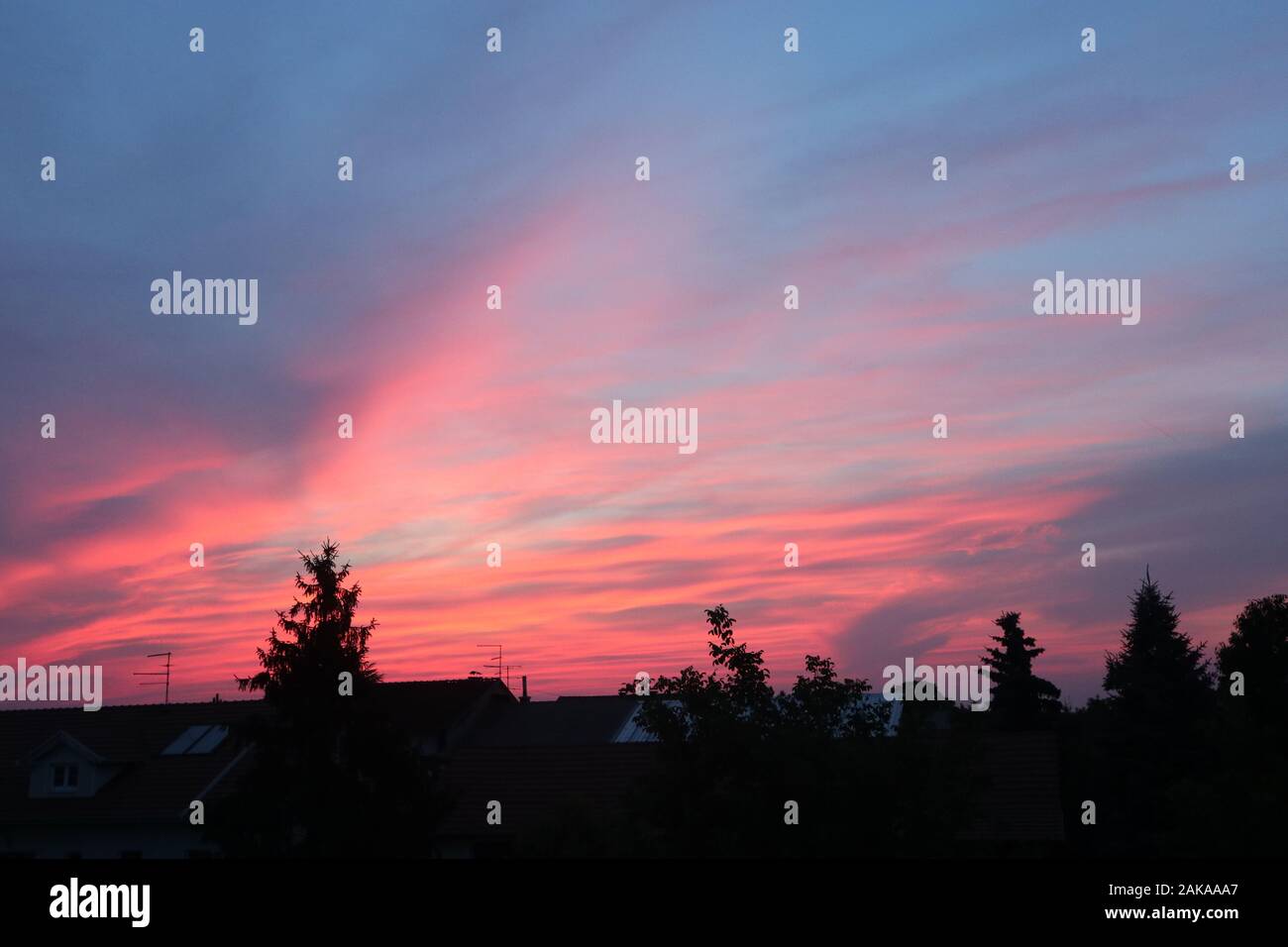 bellissimo cielo rosa fuoco sopra il villaggio Foto Stock