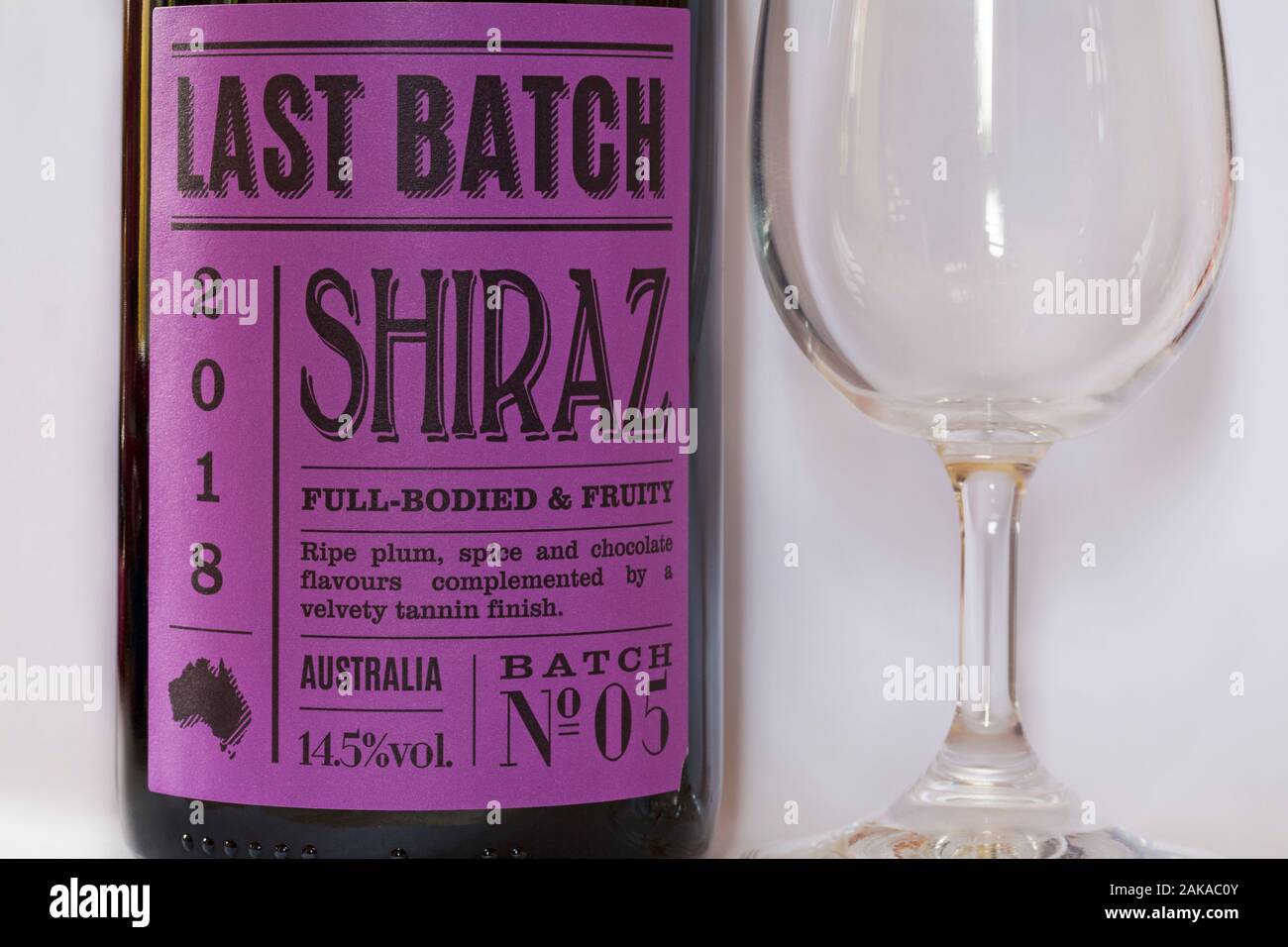 Ultima bottiglia di vino rosso Shiraz del Batch 2018 e bicchiere di vino vuoto, corposo e fruttato Foto Stock