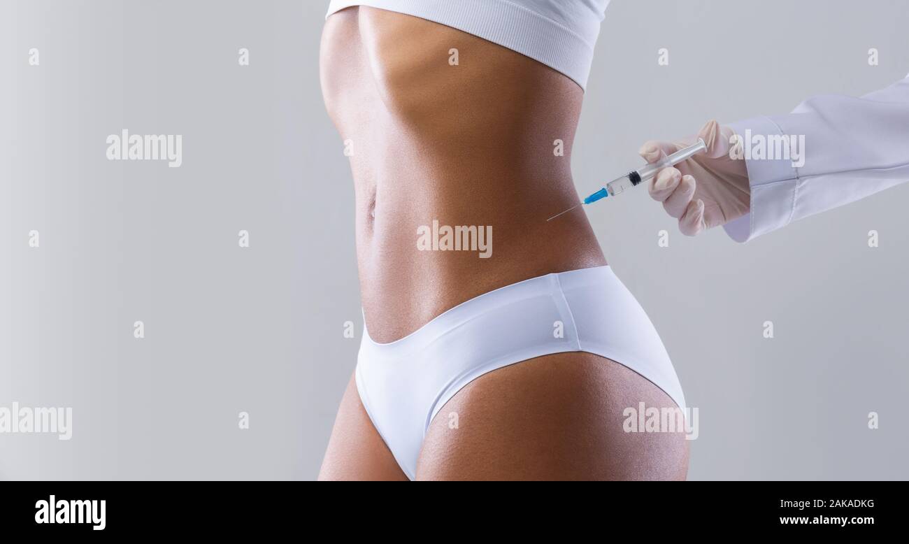 Tagliata di giovani ben montare donna nera iniezione avente nella sua vita, procedura di bellezza in salone, panorama con spazio di copia Foto Stock