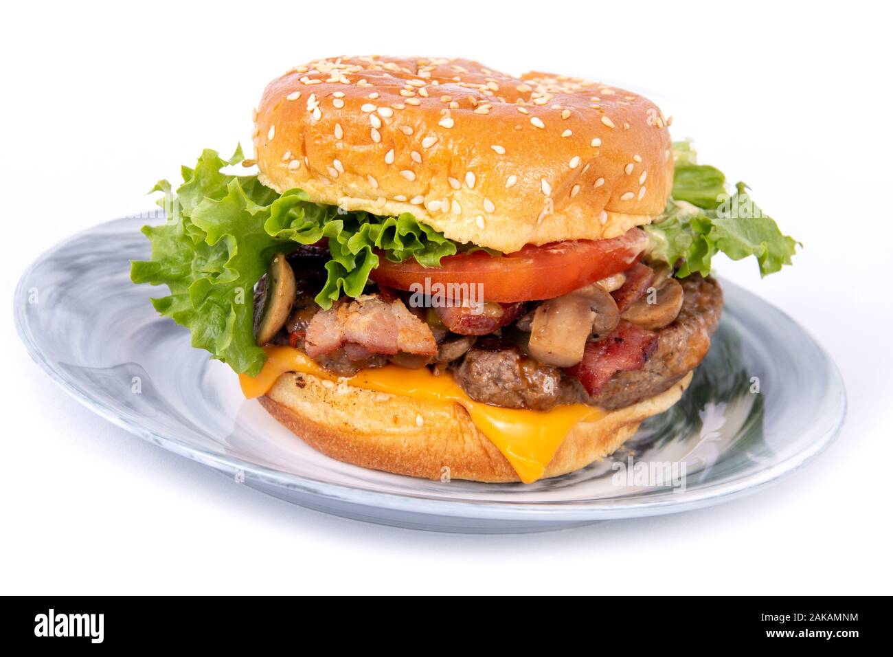 La pancetta e formaggio fungo tutti vestiti di hamburger piatto su una piastra Foto Stock