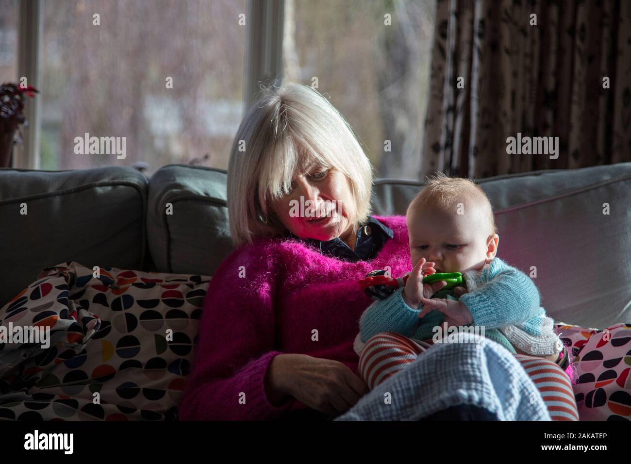 Nonna mentre tiene il suo bambino piccolo nipote. Padre e figlio Foto Stock