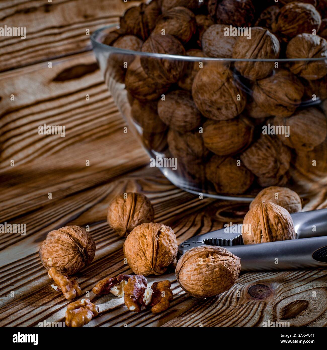 Cibo sano: Dadi rotondi con noci giacciono su di un tavolo di legno Foto Stock