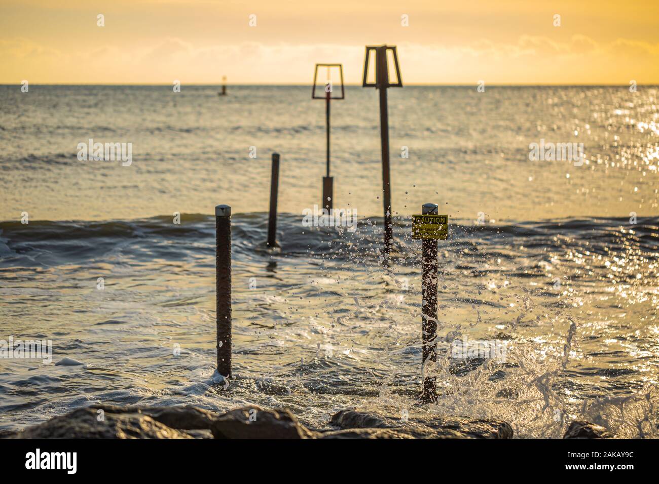 Paesaggio fotografia scattata dalla fine della spiaggia groyne a barene, Poole, di marcatori di avvertimento sulla struttura sommersa. Foto Stock