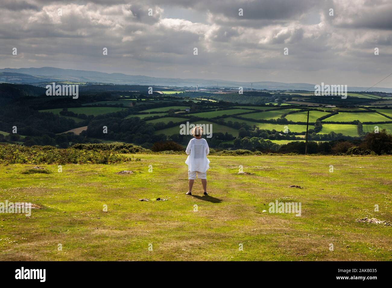 Donna che guarda sulla vallata verso cardinham legno, Bodmin Moor, Cornovaglia Foto Stock