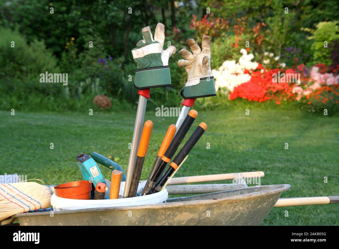 Carriola con utensili da giardinaggio nel sole di sera dopo il lavoro , concetto atmosferica per oggi è abbastanza felice di tempo in giardino Foto Stock