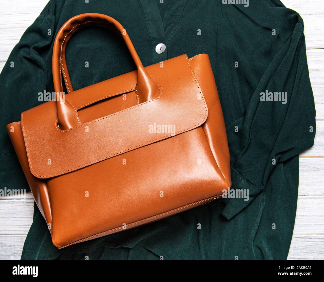 In cuoio marrone per donna borsa e camicetta verde. Le donne della primavera o estate vestito. Gli ornamenti laici piatta Foto Stock