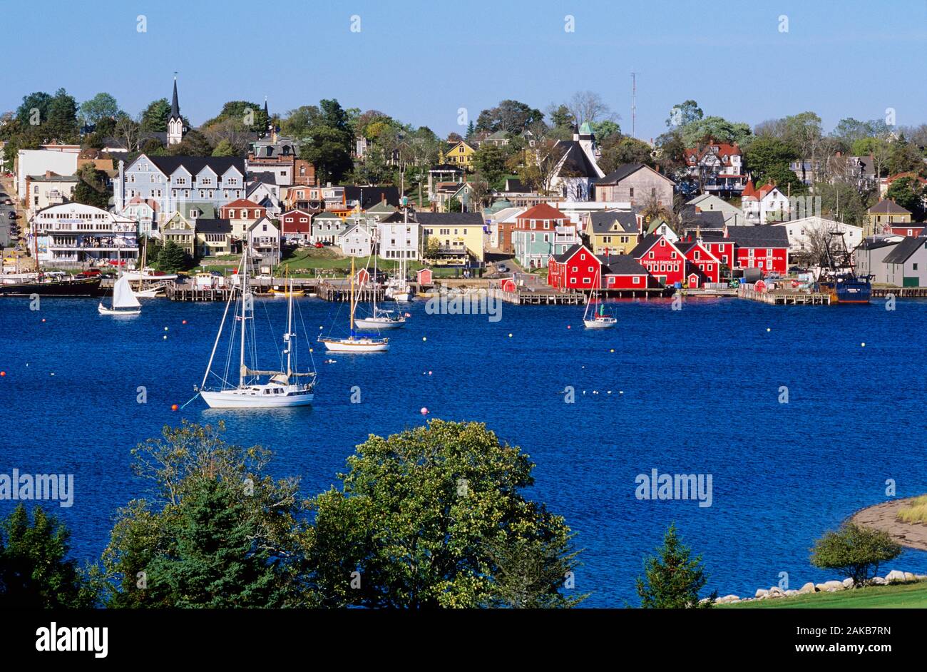 Barche a vela in mare e la città costiera di Lunenburg, Nova Scotia, Canada Foto Stock