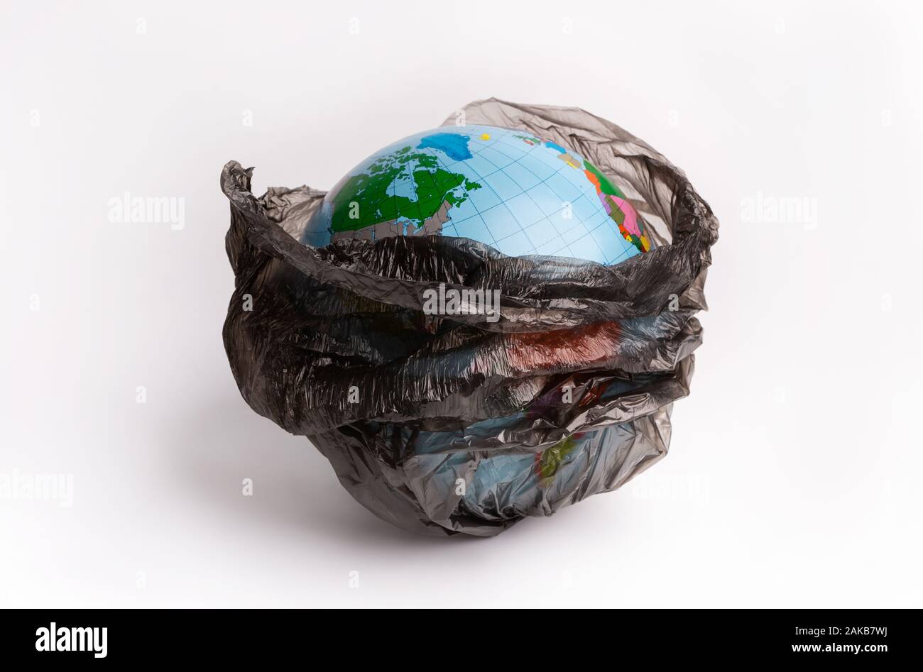 Salvare il mondo, creative ambiente inquinamento o il mondo la Giornata della Terra concetto. Globo mondo nero interno garbage bag isolati su sfondo bianco Foto Stock