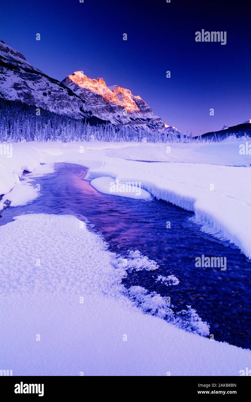 Lago ghiacciato coperto di neve in inverno al tramonto, il Parco Nazionale di Banff, Alberta, Canada Foto Stock