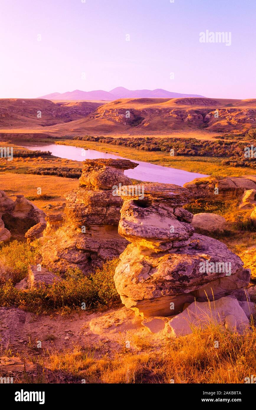 Paesaggio con formazioni rocciose e il fiume al tramonto, la scrittura su pietra Parco Provinciale, Alberta, Canada Foto Stock