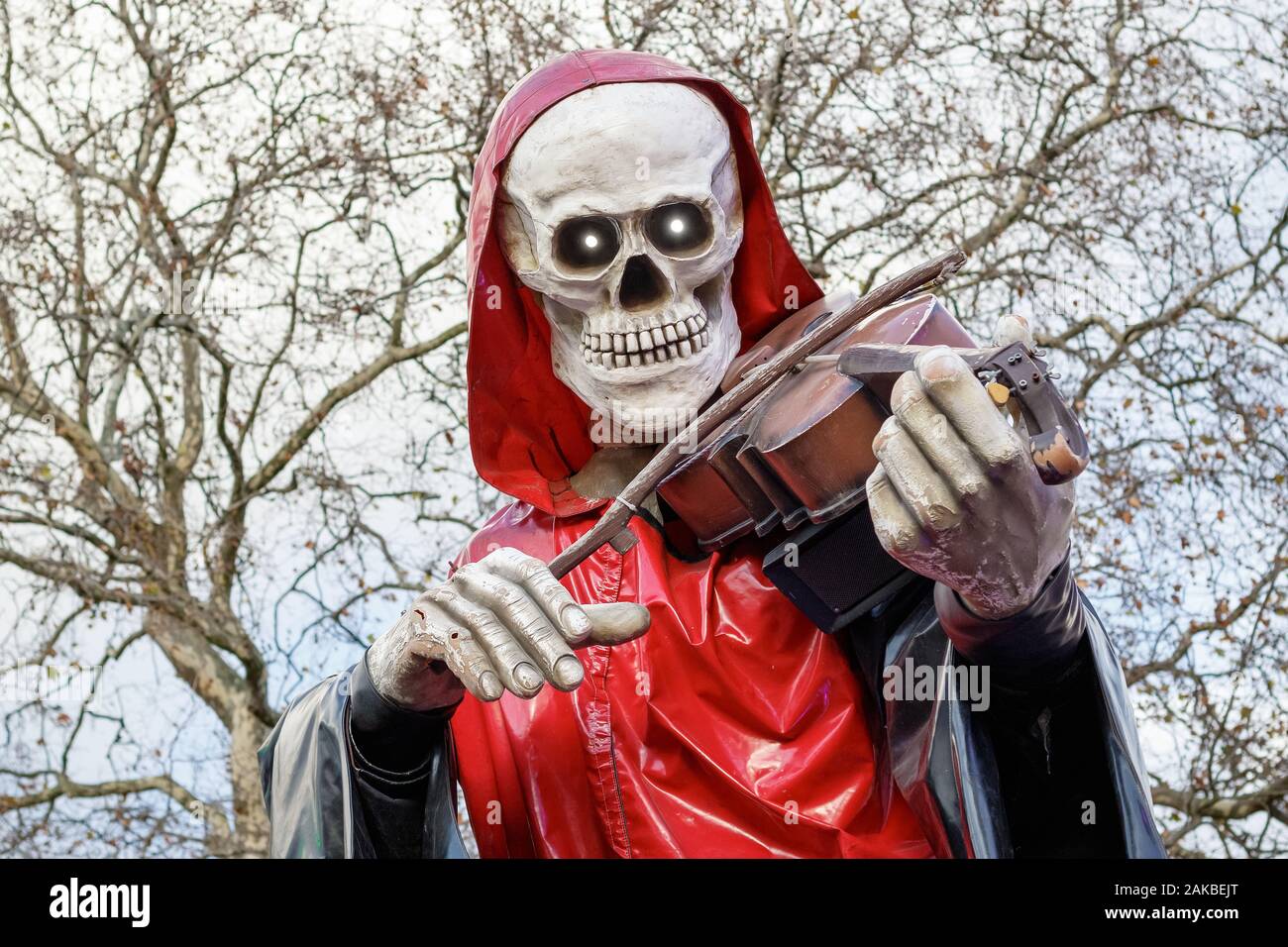 Grim Reaper, uno scheletro di figura a suonare il violino, fuori haunted attrazione a Natale luna park, Winter Wonderland a Londra Foto Stock