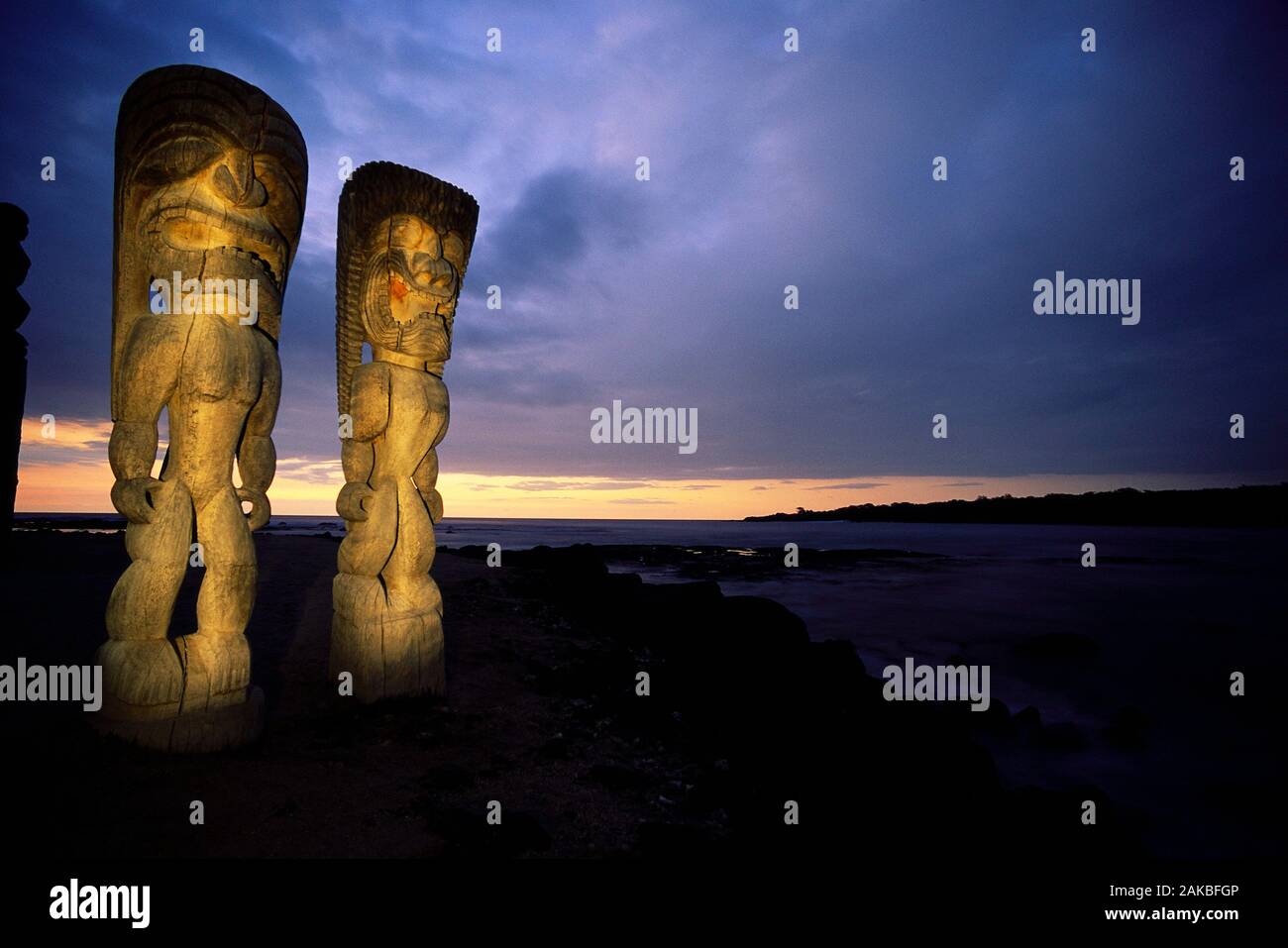 Le statue sulla spiaggia al tramonto, Puuhonua o Honaunau National Historical Park, Hawaii, STATI UNITI D'AMERICA Foto Stock