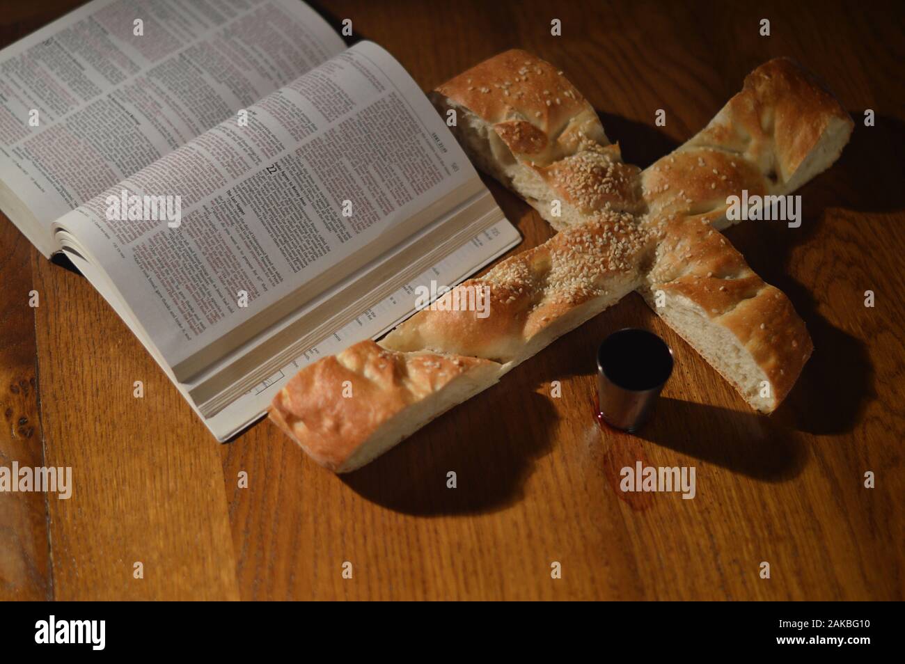 Pane a forma di croce con una Bibbia aperta a Luca 22 e un calice di vino  Foto stock - Alamy