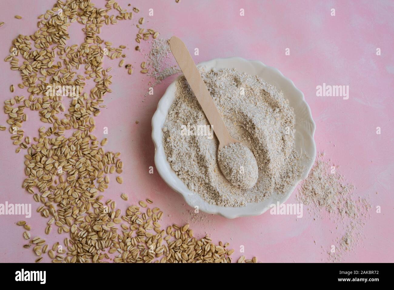 Oat ingredienti alimentari - farine e scaglie su sfondo rosa Foto Stock