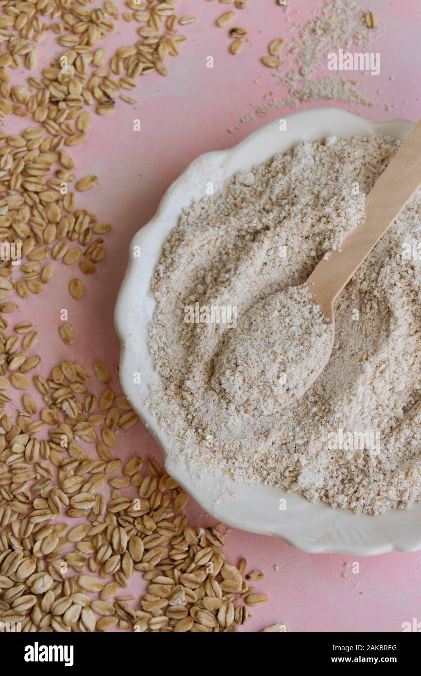 Oat ingredienti alimentari - farine e scaglie su sfondo rosa Foto Stock