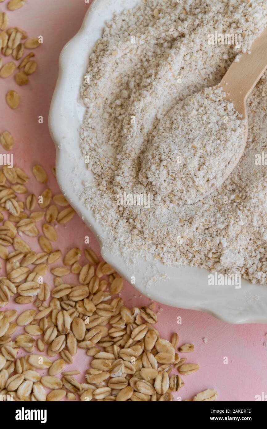 Oat ingredienti alimentari - farine e scaglie su sfondo rosa Foto Stock