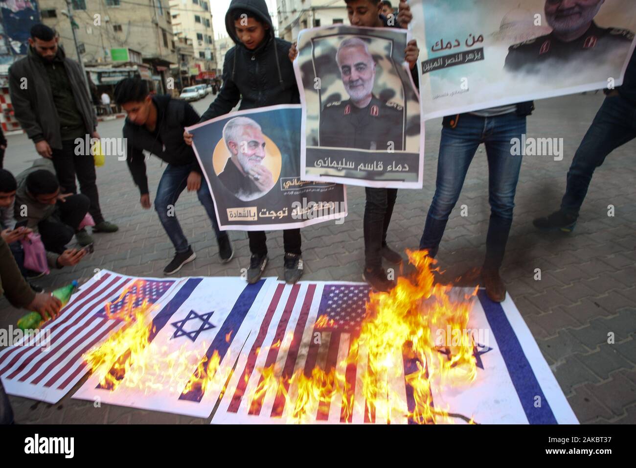 Khan Younis, Gaza. 08 gen, 2020. Dimostranti palestinesi masterizzare un noi e una bandiera Israeliana durante un raduno in Khan Yunis nel sud della striscia di Gaza mercoledì 8 gennaio 2020, organizzata in onore di uccisi iraniano comandante militare Qasem Soleimani (verticale) e per celebrare una raffica di missili sparati da Iran a noi basi militari in Iraq. Foto di Ismael Mohamad/ fino Credito: UPI/Alamy Live News Foto Stock