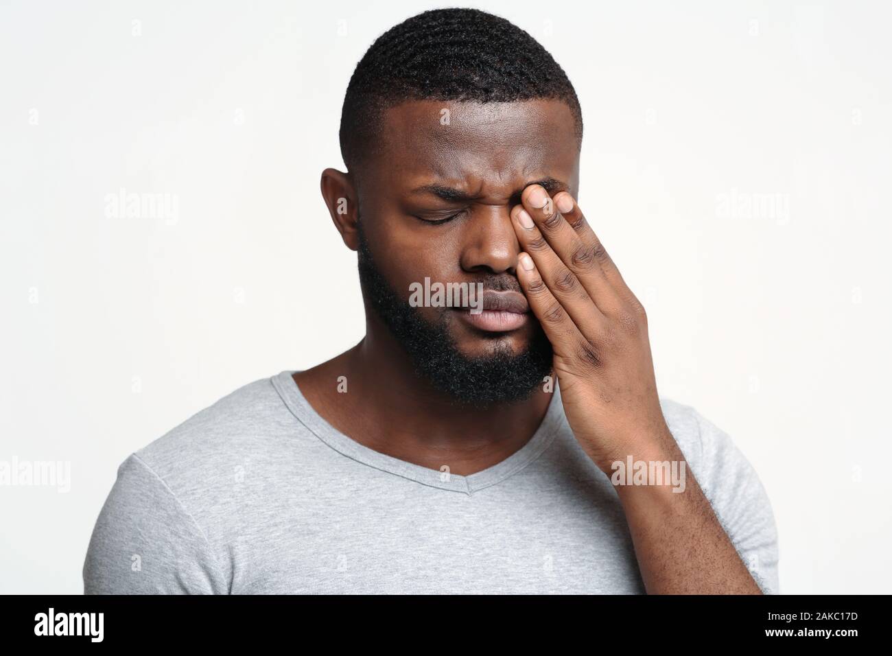 Ragazzo africano sfrega contro il suo occhio, affetti da congiuntivite, malattie oculari concept Foto Stock