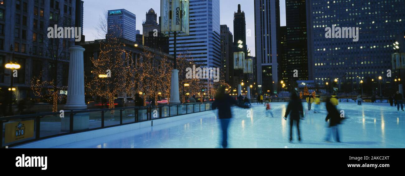 Silhouette di un gruppo di persone del pattinaggio su ghiaccio, il Millennium Park il pattinaggio su ghiaccio, Grant Park, Chicago, Illinois, Stati Uniti d'America Foto Stock