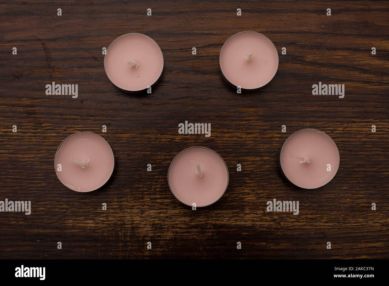 Close-up di tè rosa candele di luce sullo sfondo di un vecchio tavolo in legno Foto Stock