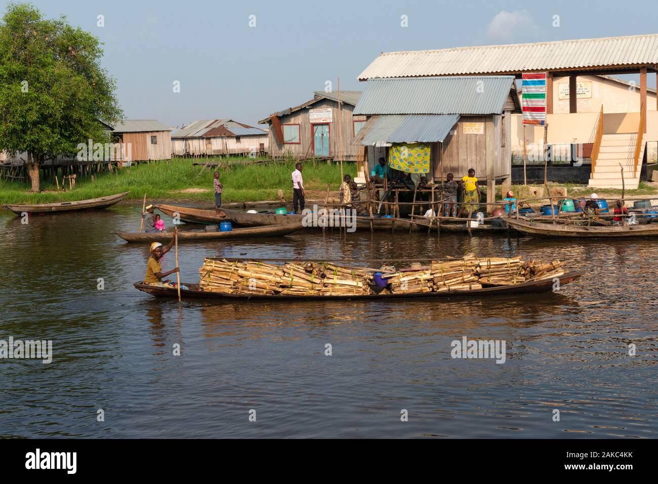 Il Benin, Lakeside città di Ganvié, commerciante di legno sulla sua piroga Foto Stock
