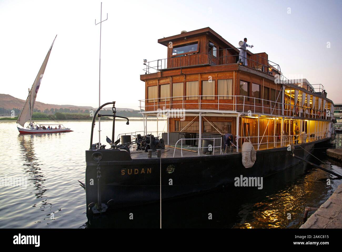 Egitto Alto Egitto, Valle del Nilo, la nave a vapore il Sudan, l'ultimo steamboat crociera sul Nilo, ormeggiata su una banca con una Feluca di attraversare il fiume in background Foto Stock