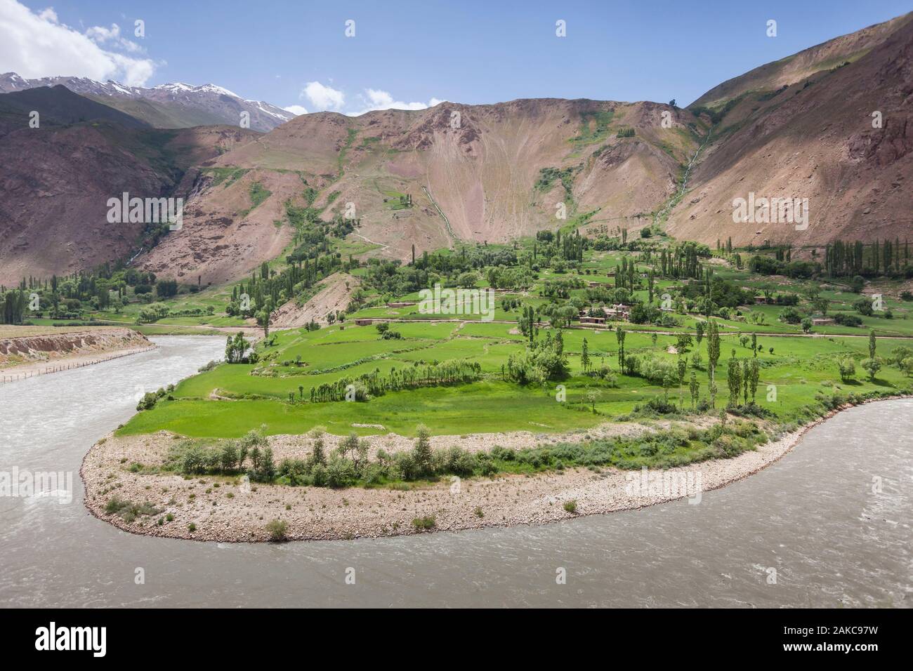 Tagikistan, Gorno-Badakhshan Regione autonoma, serpeggiante Fiume Piandj, verde delle culture e delle montagne del deserto, Afghanistan visto dal Tagikistan Foto Stock