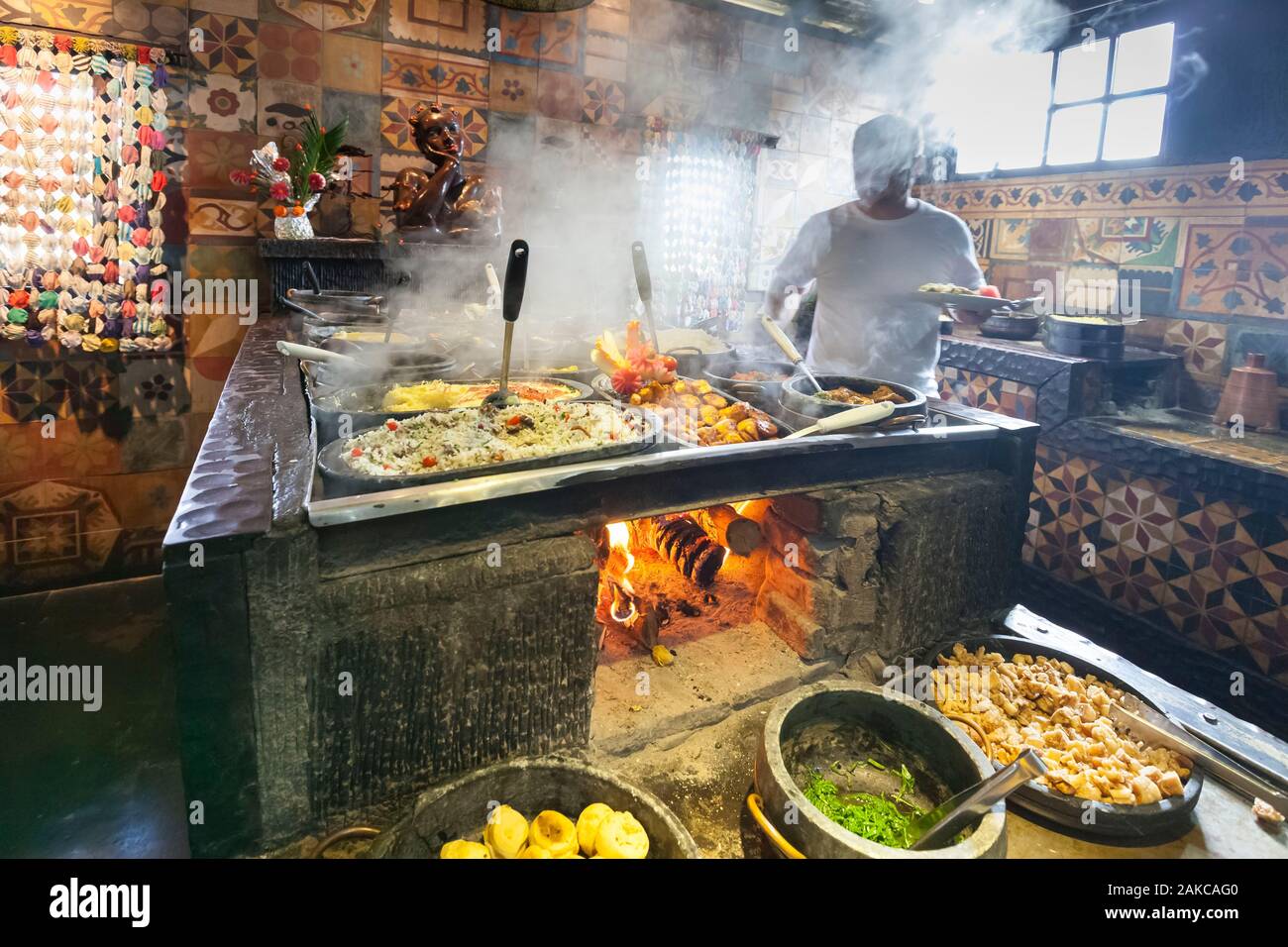 Il Brasile, Minas Gerais stato, Belo Horizonte Vila ristorante rurale e tradizionale cucina Minera buffet, aiutando il cliente stesso in piatti simmering su un fuoco di legno Foto Stock