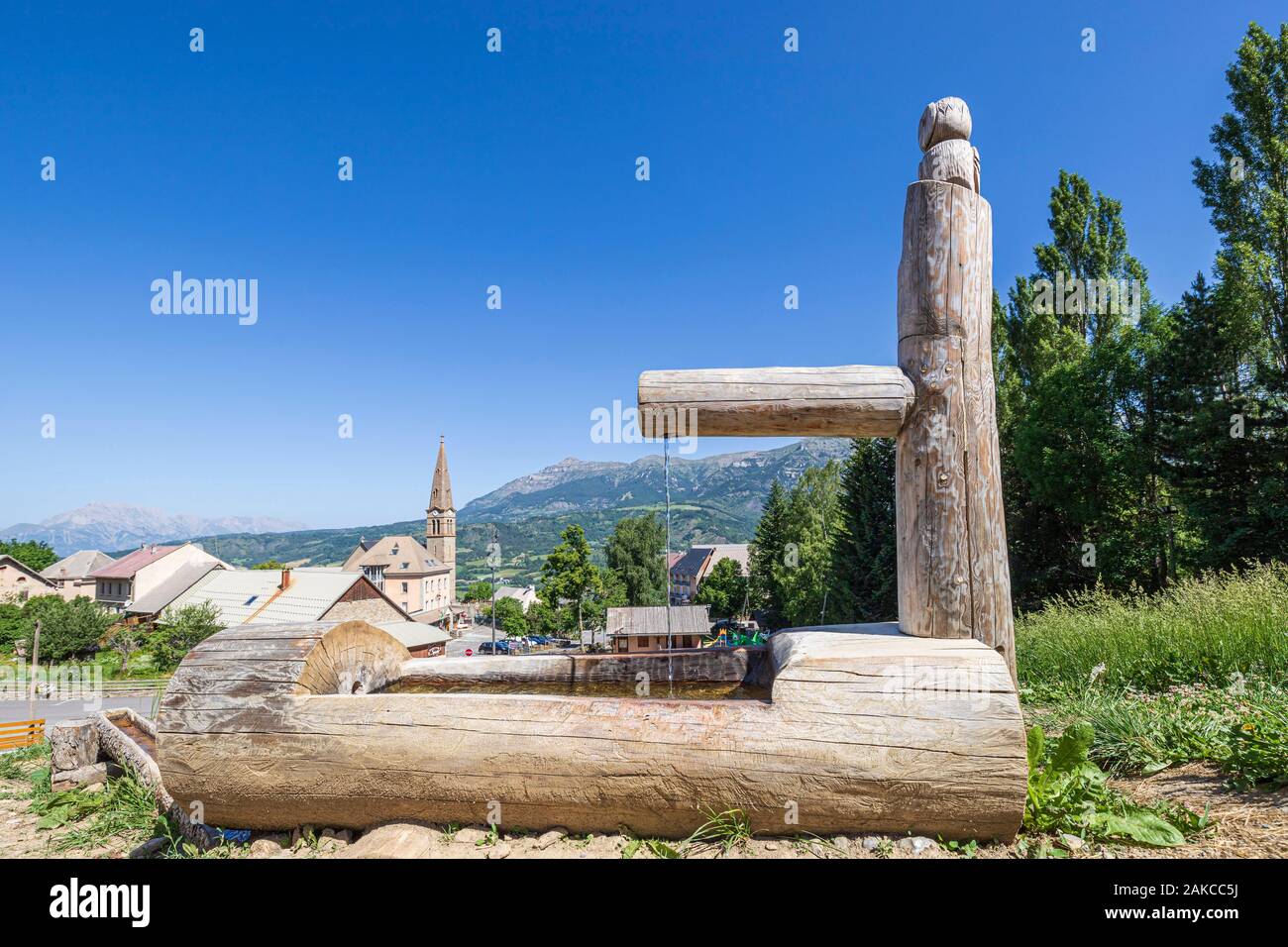 Francia, Hautes Alpes, Parco Nazionale degli Ecrins, Champsaur Valley, Saint Léger les Mélèzes, fontana scolpita in un tronco di albero Foto Stock