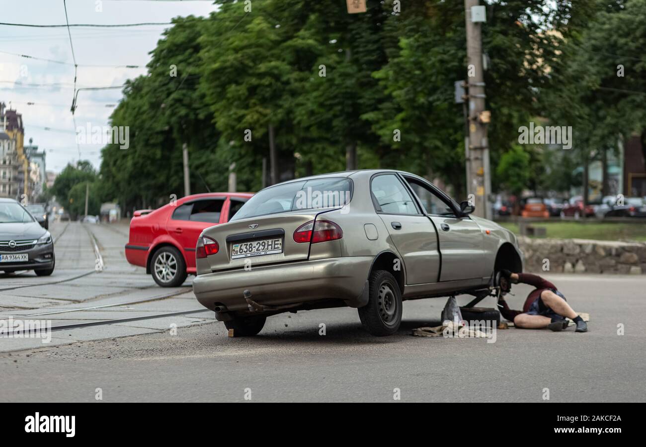 Kiev, Ucraina, Giugno 08, 2019. Uomo cambia la ruota sulla strada Foto Stock
