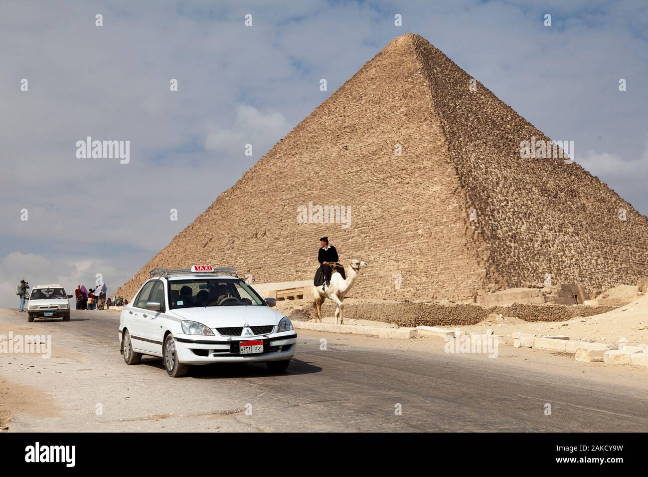 La gente in giro per le Piramidi di Giza in taxi e cammelli in città del Cairo, Egitto Foto Stock