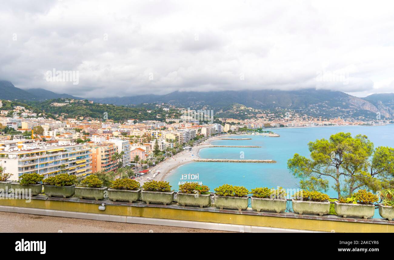Vista panoramica dall'autostrada guardando verso il basso sulla riviera resort città di Roquebrune-Cap-Martin, Francia, su un nuvoloso giorno d'estate. Foto Stock