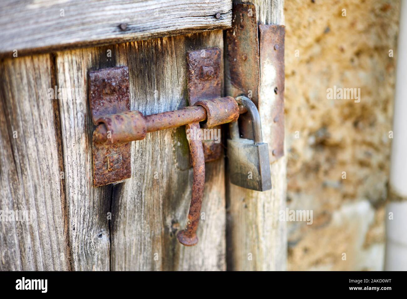 Immagine di un arrugginito lo scorrimento boor bullone con lucchetto sulla botte vecchia porta. Foto Stock