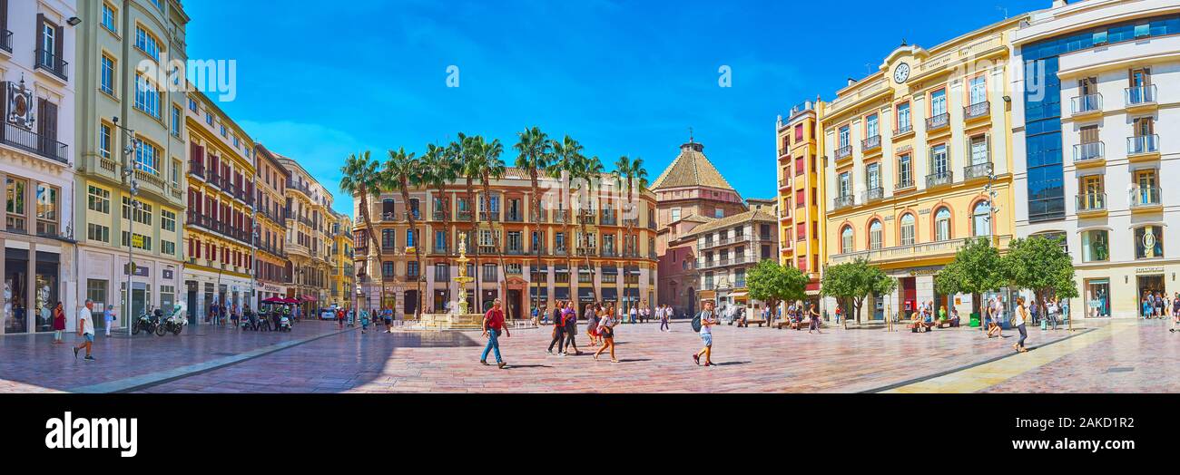 MALAGA, Spagna - 26 settembre 2019: Panorama di Piazza della Costituzione con negozi e caffetterie in edifici classici e scolpita in pietra Fontana di Genova in fro Foto Stock