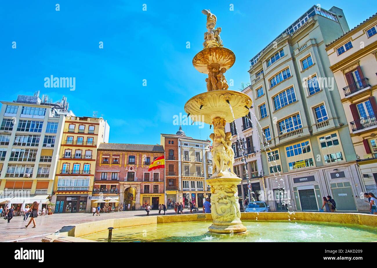 MALAGA, Spagna - 26 settembre 2019: la vista su edifici di Plaza de la Constitucion (Piazza della Costituzione) attraverso il marmo bianco Fontana di Genova, o Foto Stock