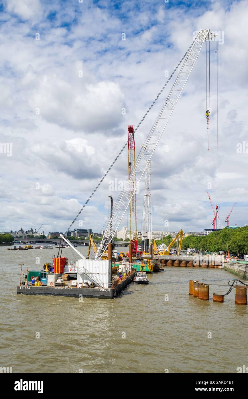 La Thames Tideway sotto regime di costruzione con macchinari pesanti su chiatte sul fiume, London, Regno Unito Foto Stock