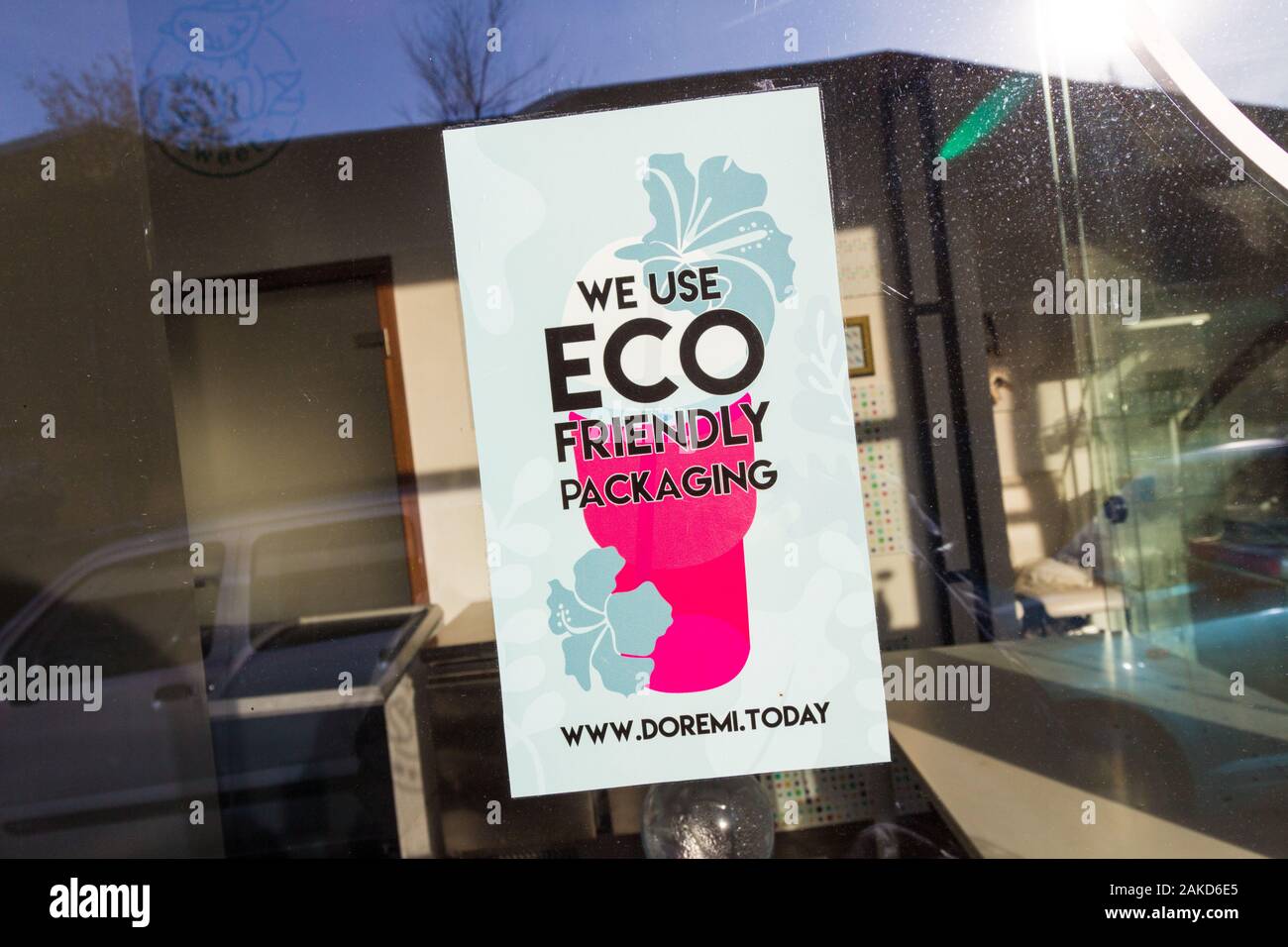 Dobbiamo utilizzare confezioni eco-compatibili Doremi segno sul negozio di vetro anteriore del muhely Csiz negozio di dolci, Sopron, Ungheria Foto Stock