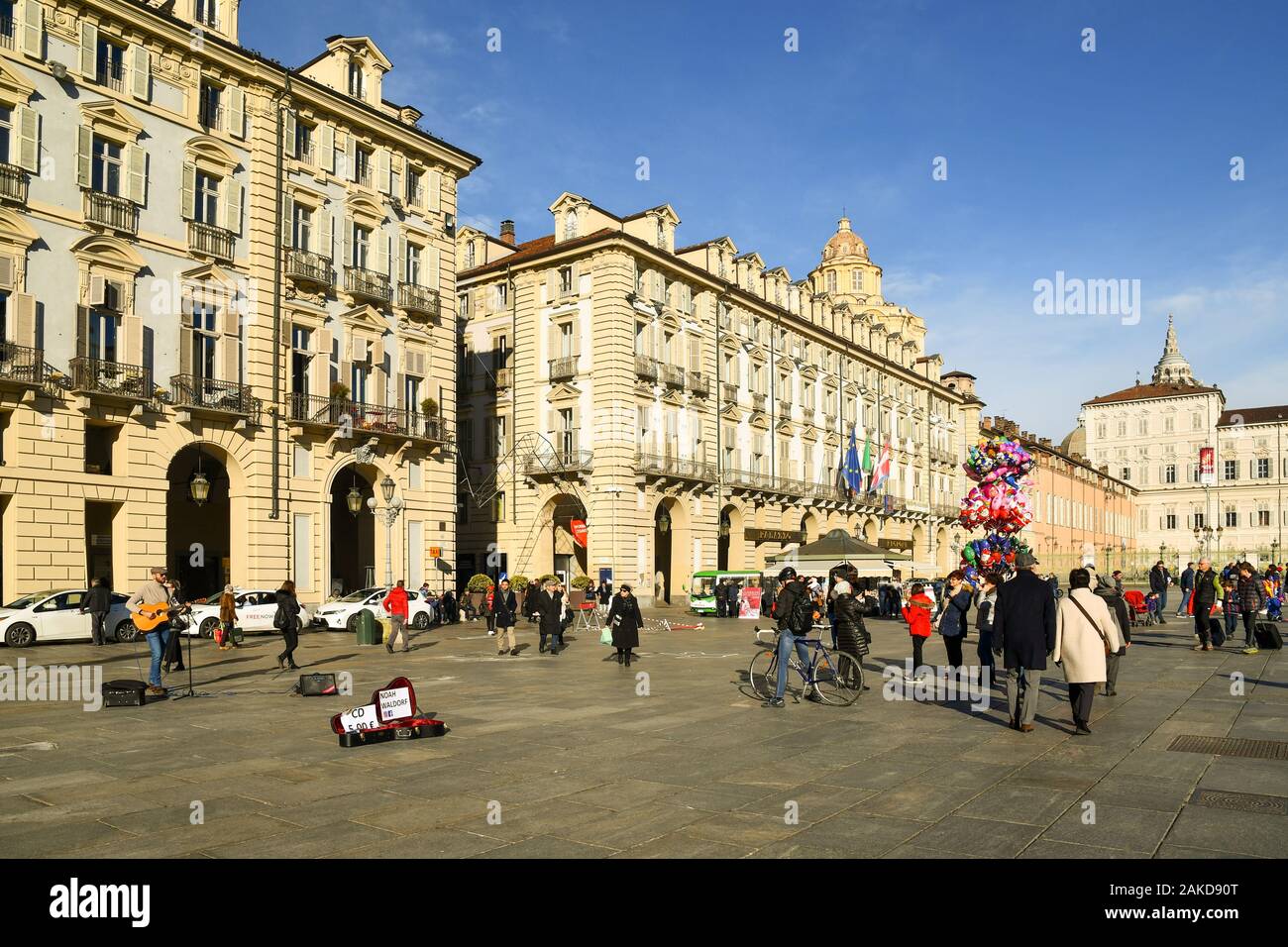 Scorcio di Piazza Castello nel centro di Torino con un musicista di strada, cittadini e turisti in una giornata di sole prima di Natale, Piemonte, Italia Foto Stock