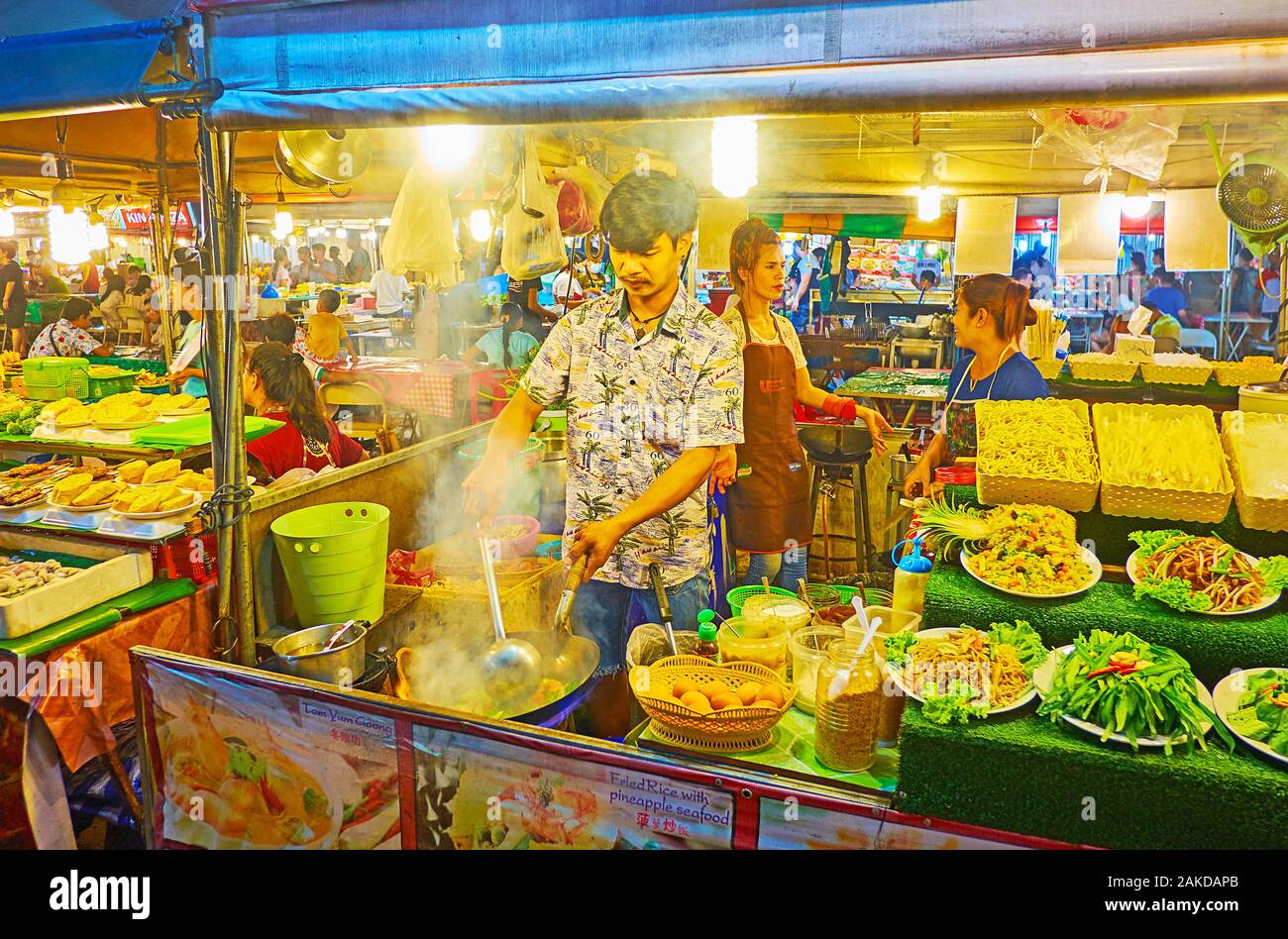 PATONG, Tailandia - 1 Maggio 2019: Lo chef del piccolo cafe cuochi rosolare le verdure in cucina all'aperto di Bangla street food court, il 1 maggio in Paton Foto Stock