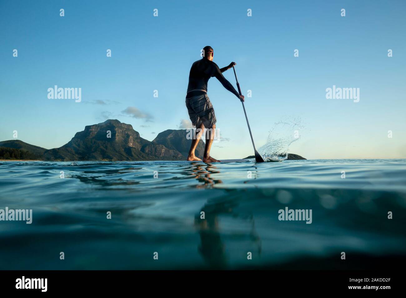 Uomo Stand Up paddle boarding sulla Calma acqua di mare Lord Howe Island Foto Stock
