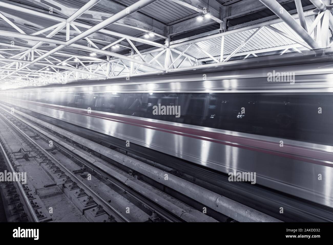 Treno della metropolitana si muove velocemente attraverso la stazione di interni. Foto Stock