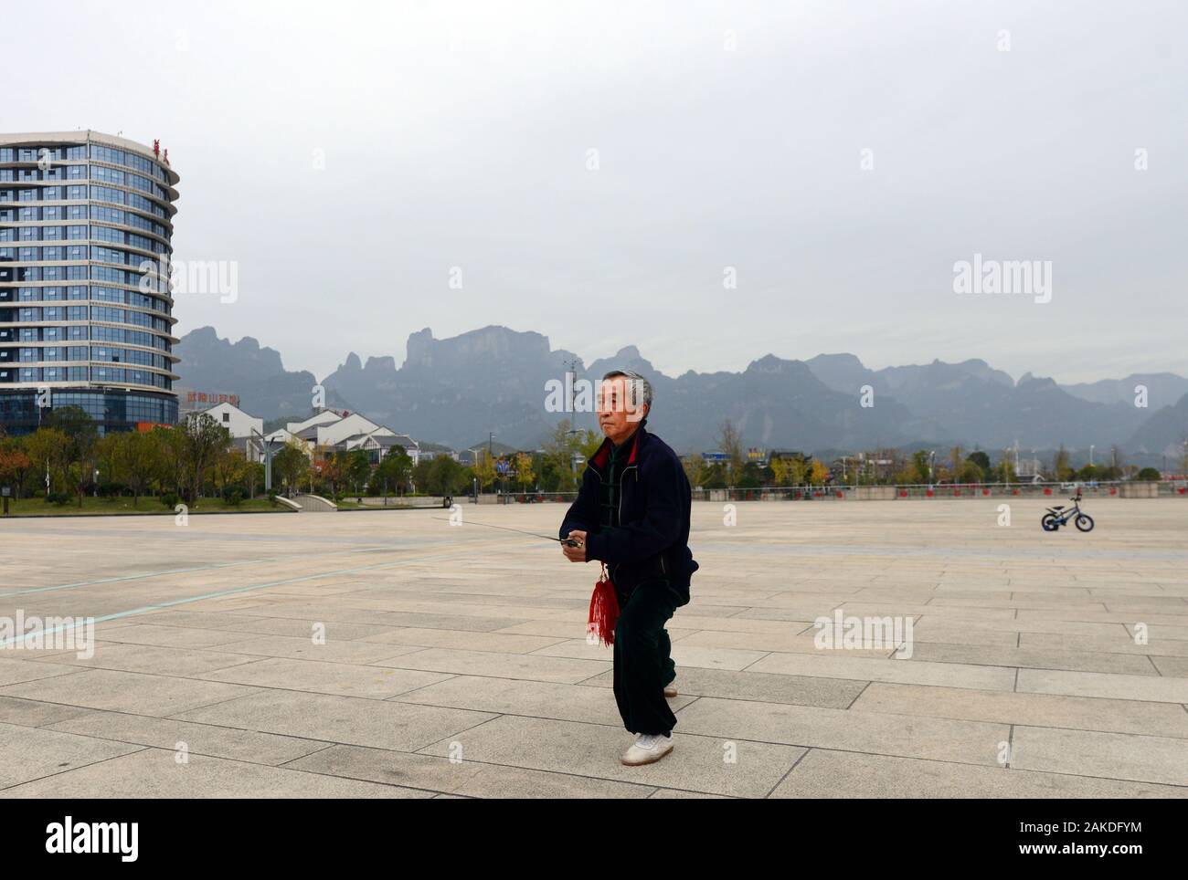 Un uomo cinese che pratica Tai Chi nella città di Zhangjiajie a Hunan, Cina. Foto Stock