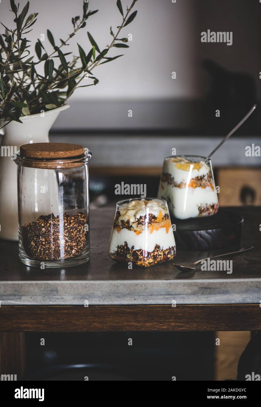 Sana colazione con yogurt, muesli e frutta in bicchieri Foto Stock