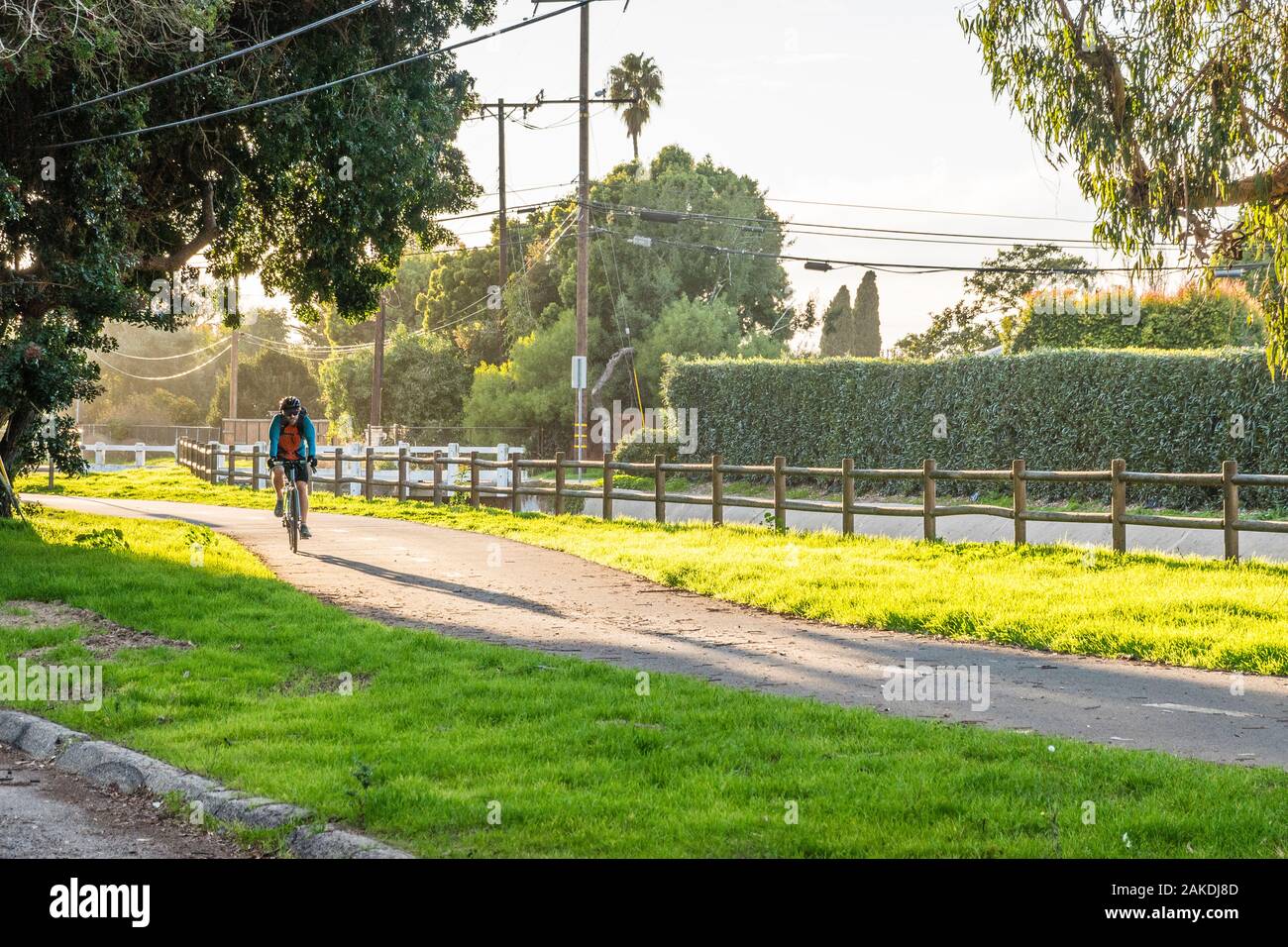Un molto usato il percorso in bicicletta nel tardo pomeriggio luce drammatica con un maschio di bike rider passeggiate sul percorso. Foto Stock